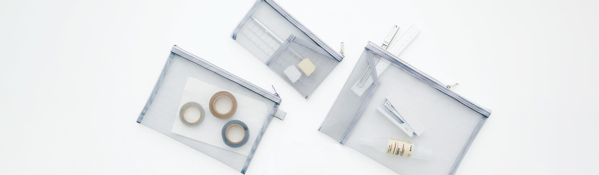 Three MUJI Pen Clear Cases Housing Various Office Supplies.