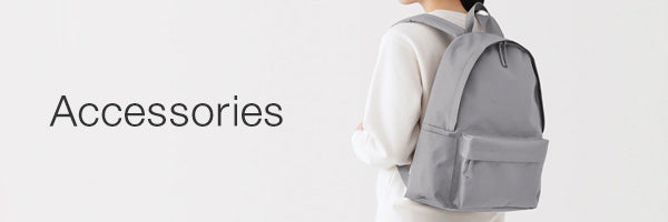 A person wearing a light gray backpack, shown from the back against a clean white background with the word 'Accessories' on the left.
