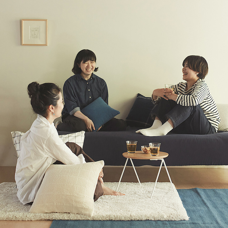 Women enjoying a drink using MUJI glassware.