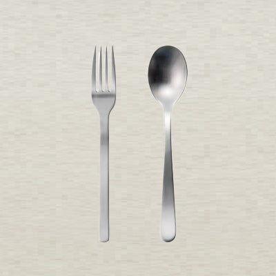 Stainless steel fork and spoon on a textured beige background